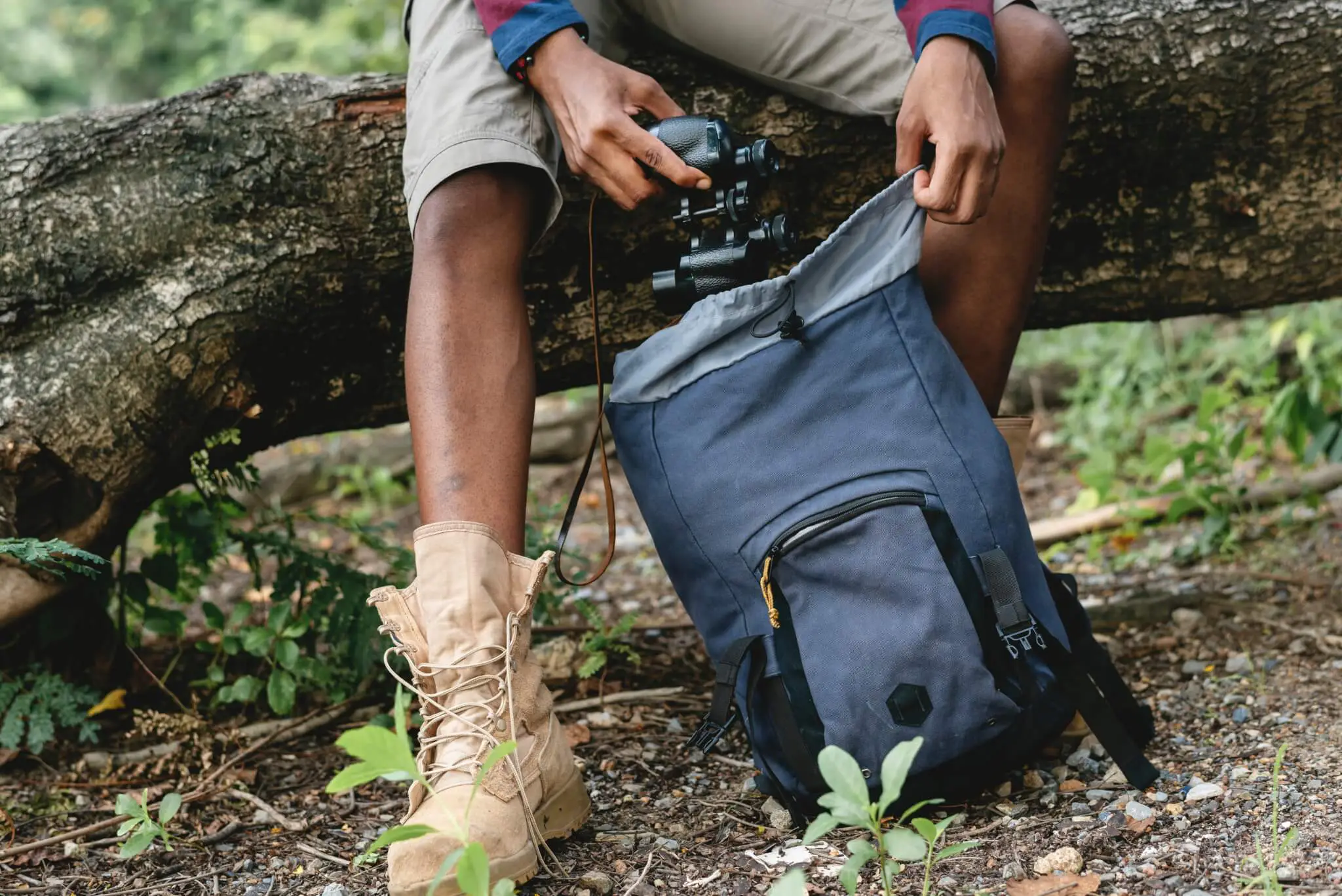 A man pulling a camera out of a backpack.