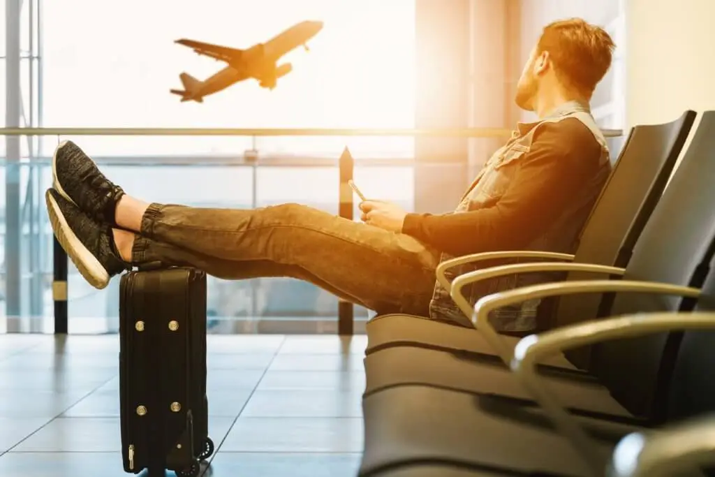 Man in suit at airport watching an airplane take off