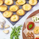 A flatlay of homemade crostini next to crostini pieces with various toppings.