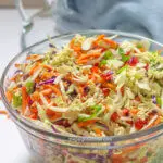 A clear serving bowl filled with ramen noodle salad.