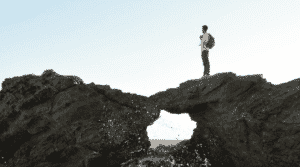 A man standing on a cliff in Italy.