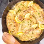 Lemon chicken piccata in a cast iron serving dish.