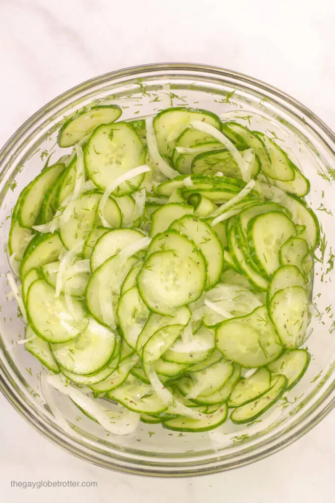 A bowl of cucumber salad ready to be chilled.