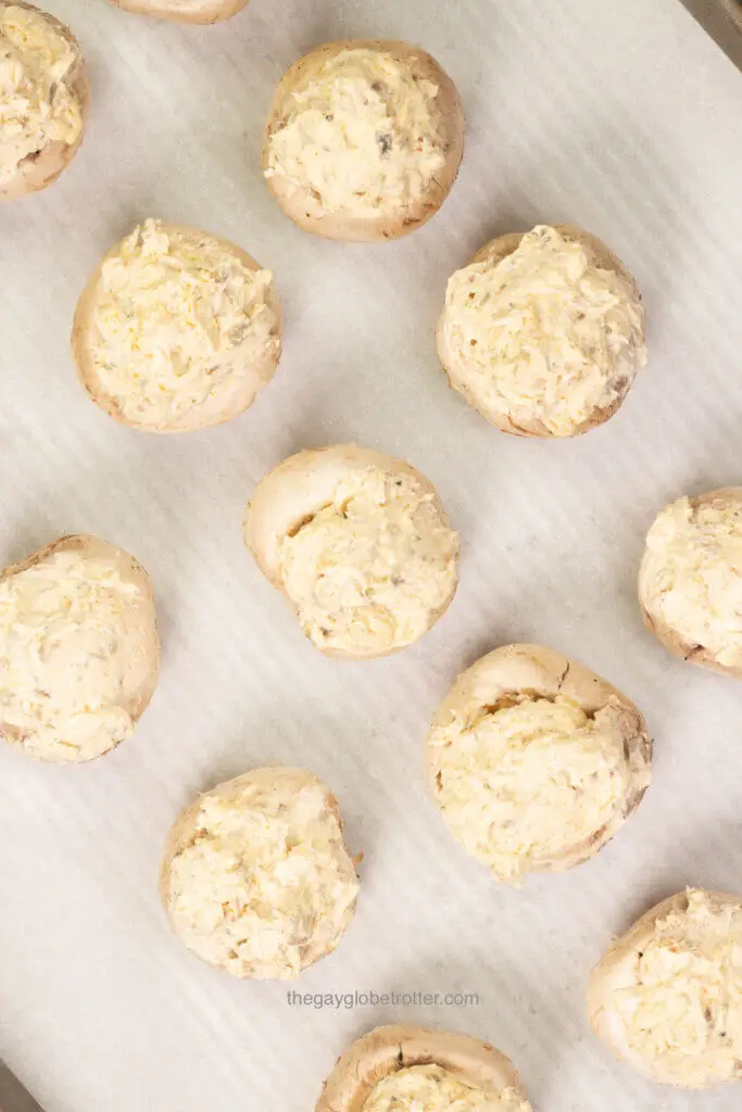 A process shot showing mushrooms being stuffed with cream cheese filling.