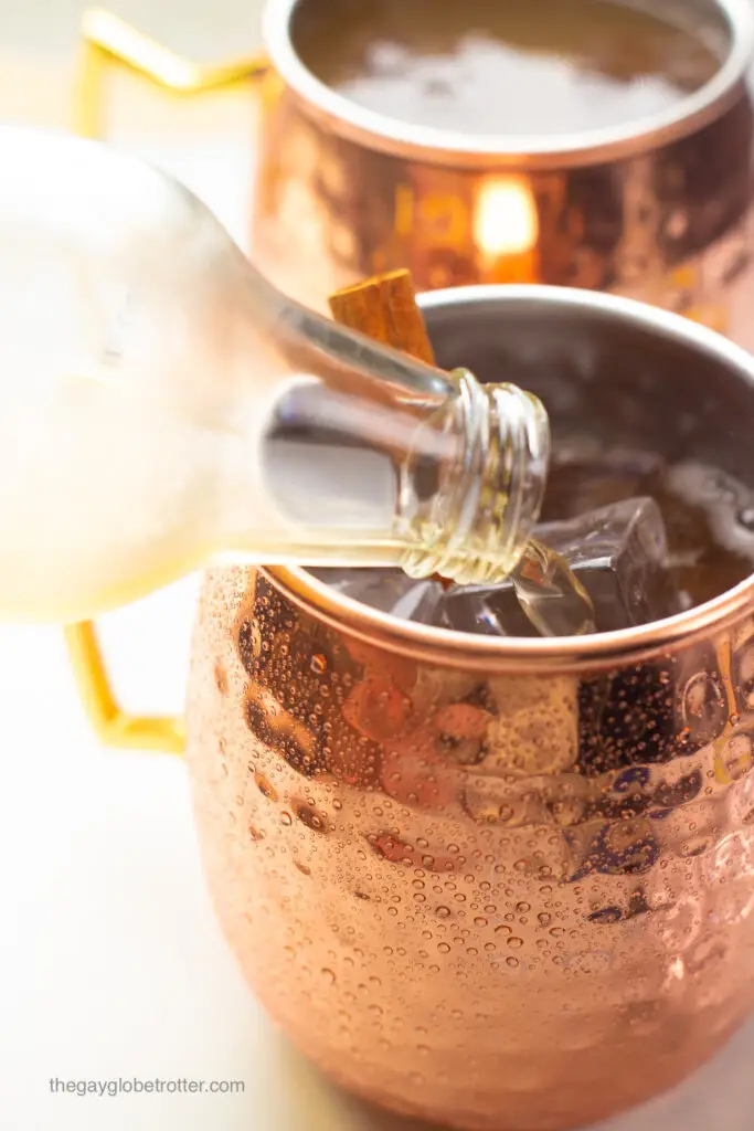 Ginger beer being poured into a copper mug for moscow mules.