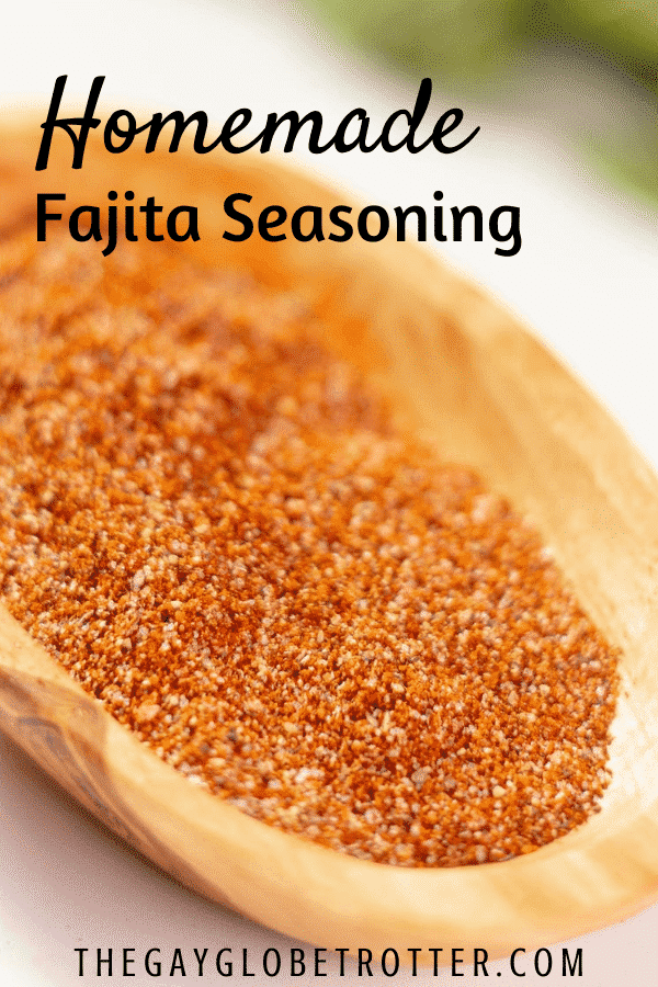 Fajita seasoning in a wooden dish with text overlay that says "homemade fajita seasoning"