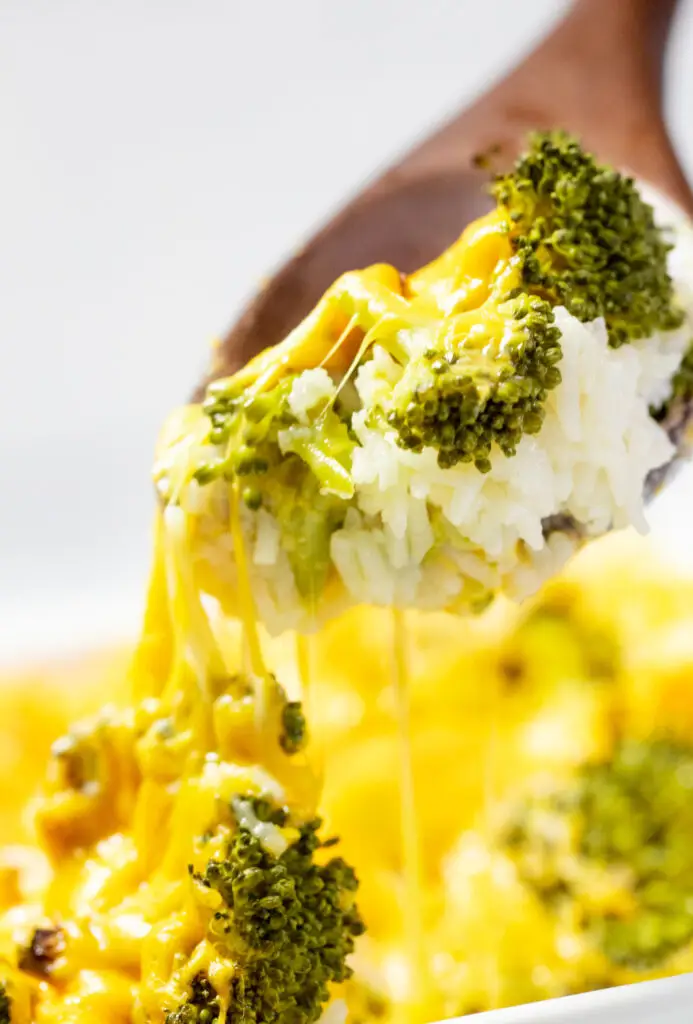 A spoon serving cheesy broccoli and rice casserole.