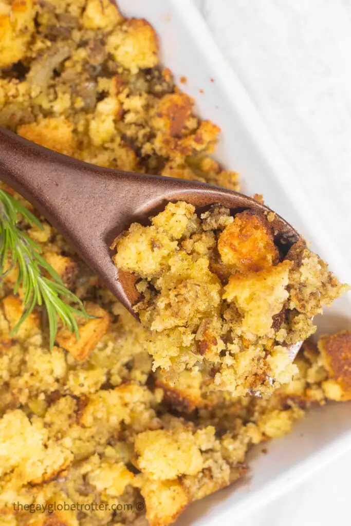 A serving spoon serving cornbread stuffing.