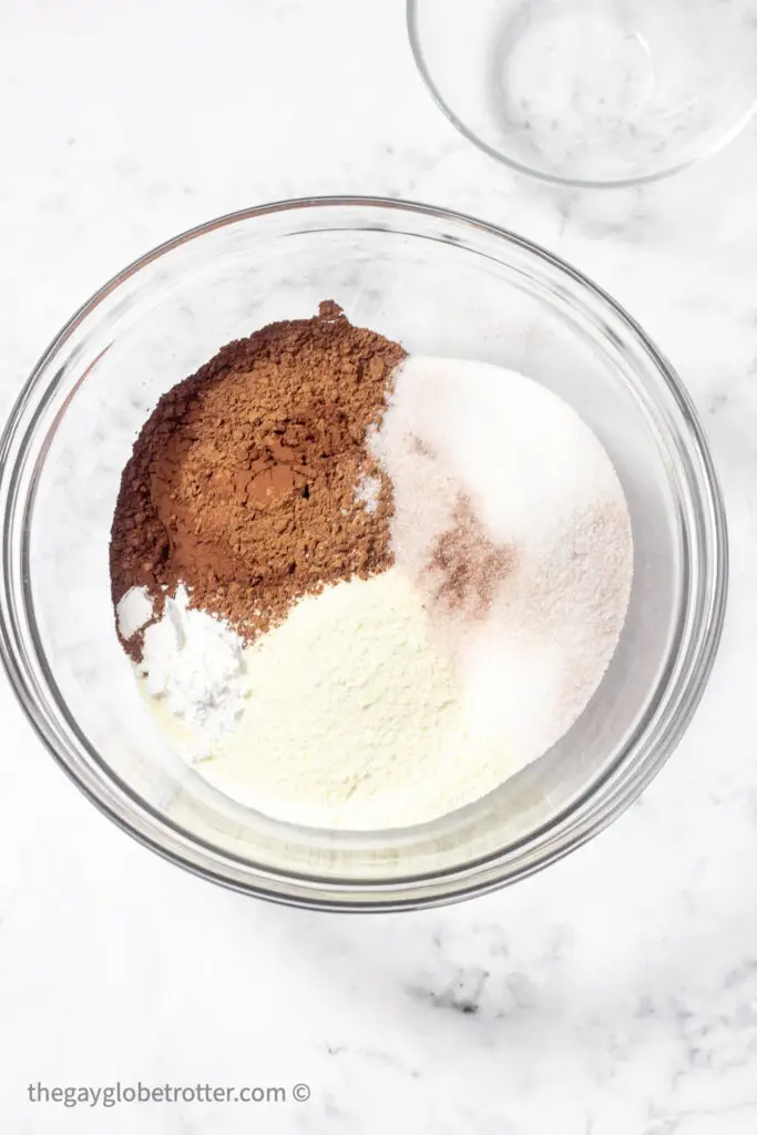 A bowl with ingredients for homemade hot chocolate mix like cocoa powder and sugar.