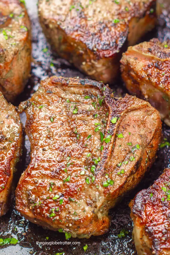 Lamb loin chops being seared in a pan.