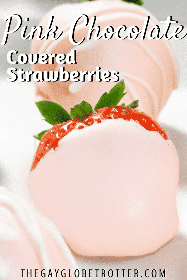 A pink chocolate covered strawberry on a serving plate.