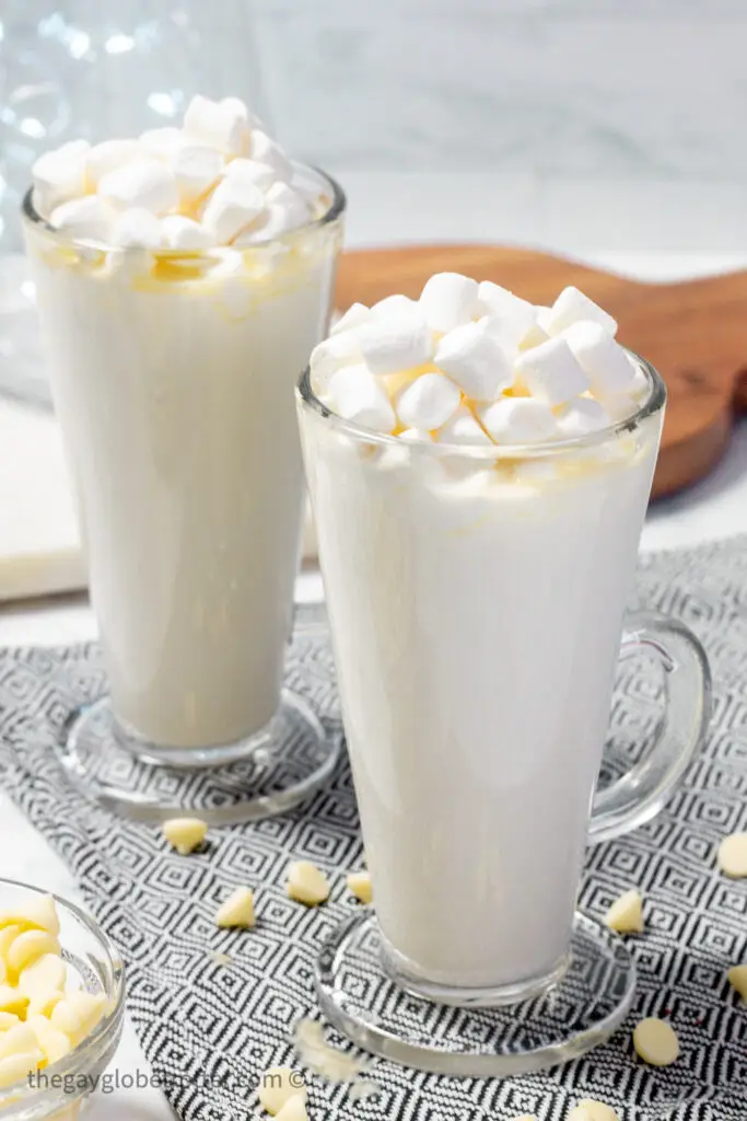 Two cups of white hot chocolate topped with marshmallows.