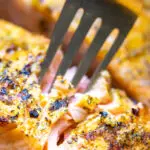 A fork taking a piece of air fryer salmon.