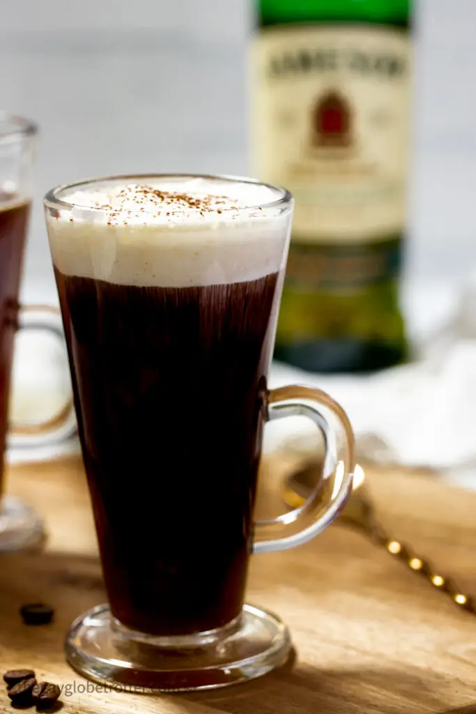 Whipped cream being added to Irish coffee.