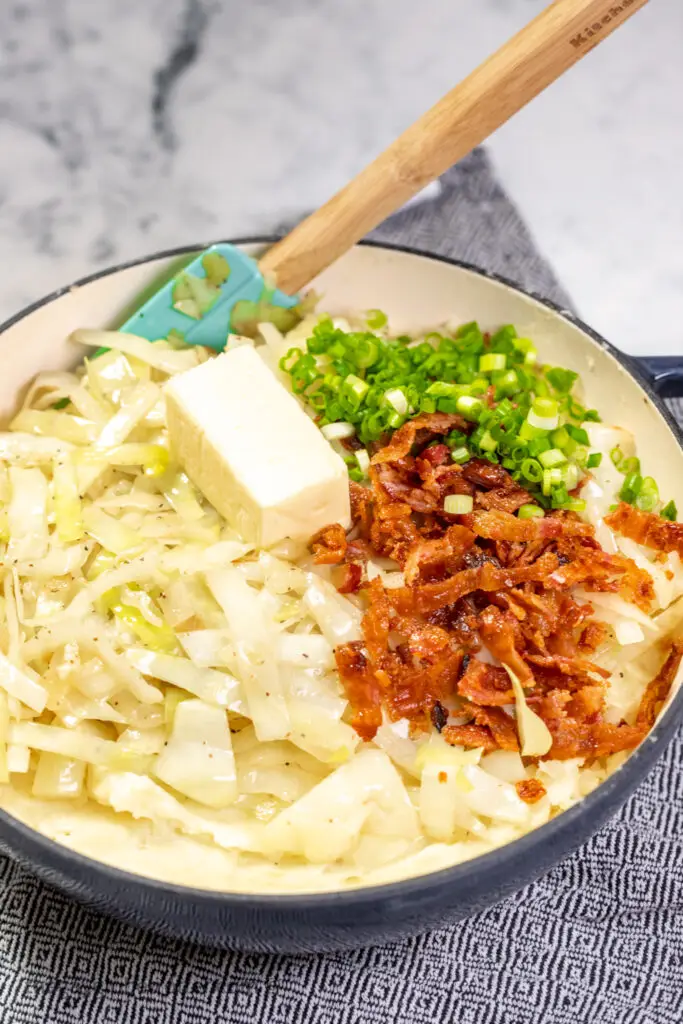 Bacon, cabbage, butter, and mashed potatoes in a bowl.