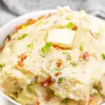 Colcannon in a serving dish topped with butter.