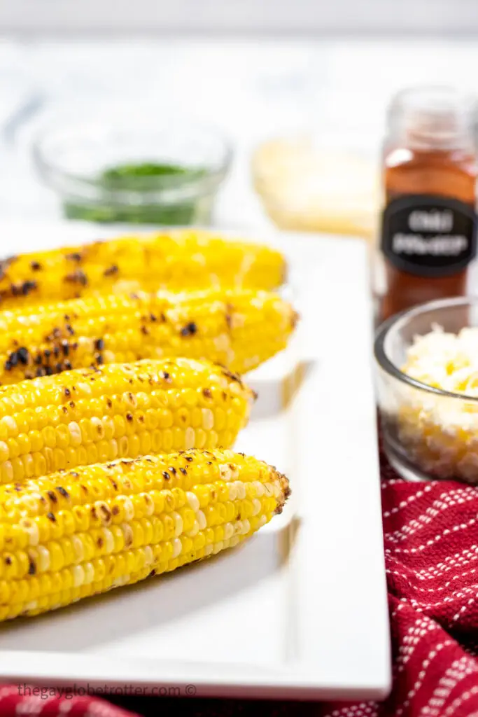 Grilled corn on a working surface with cilatnro.