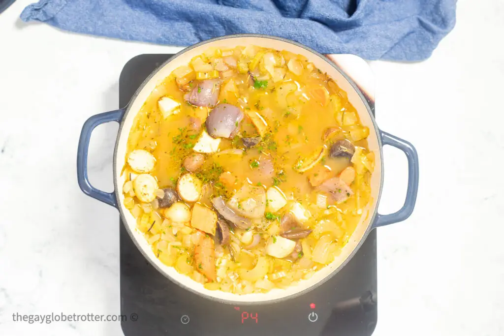 Roasted root vegetable soup simmering on a stove.