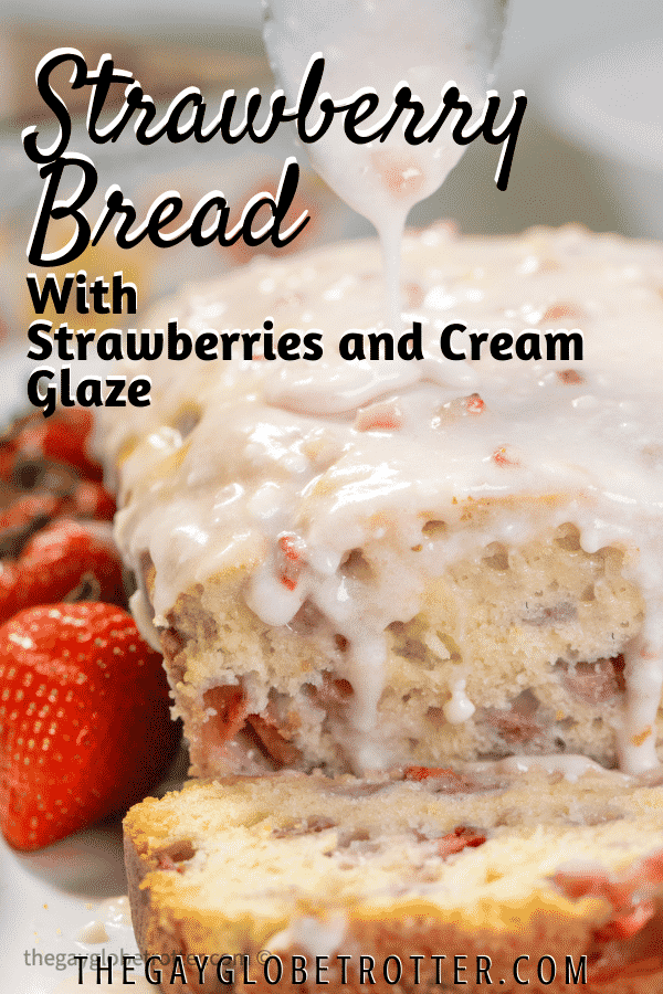 Strawberry bread with glaze next to strawberries on a serving dish.