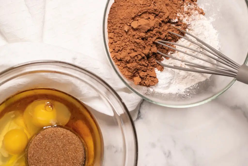 2 mixing bowls with wet and dry cookie dough ingredients.