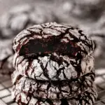 4 chocolate crinkle cookies stacked in a pile.