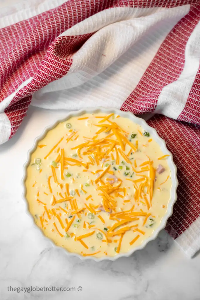 Egg mixture being poured into a pie dish.