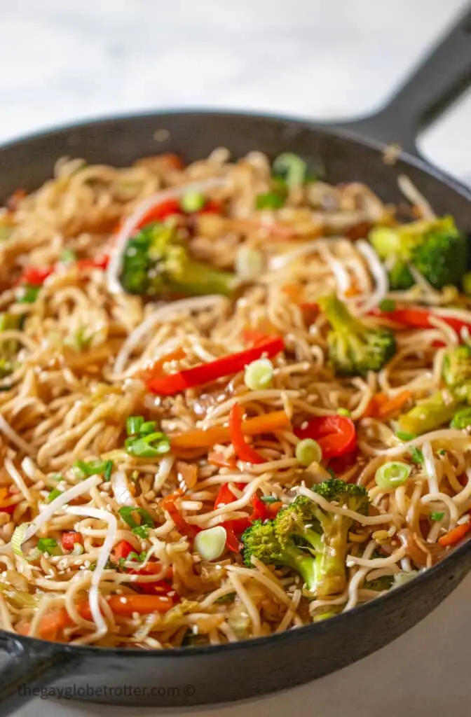 A cast iron pan with vegetable lo mein.